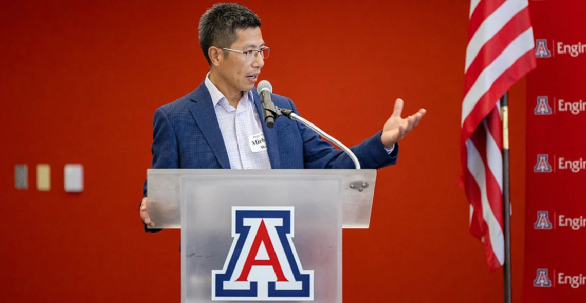 Michael Wu speaks from a University of Arizona podium
